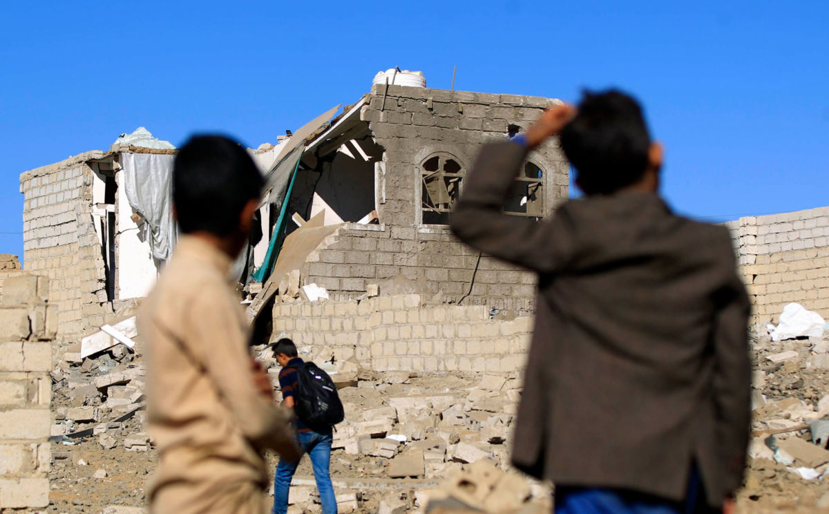 Yemenis look at a building destroyed in Saudi-led air strikes in Yemen's capital Sanaa on February 1, 2019.