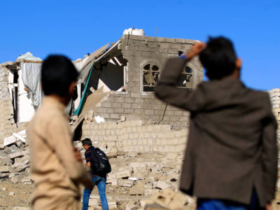 Yemenis look at a building destroyed in Saudi-led air strikes in Yemen's capital Sanaa on February 1, 2019.