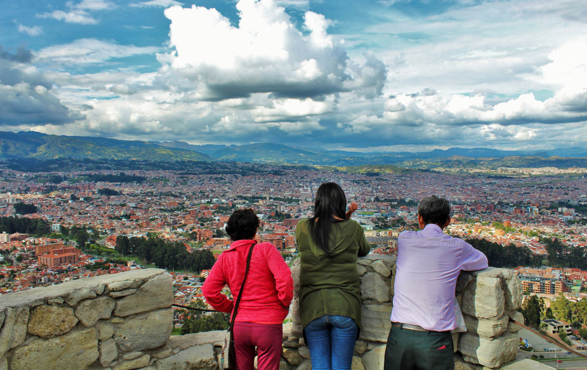 A family looks at a view of Cuenca, Ecuador. Retirees and lifestyle migrants are bringing gentrification and dispossession to local communities.