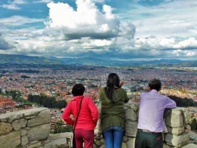 A family looks at a view of Cuenca, Ecuador. Retirees and lifestyle migrants are bringing gentrification and dispossession to local communities.