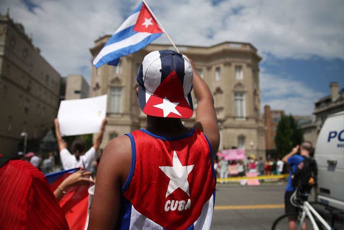 A Cuban supporter waves a Cuban flag in front of the country's embassy after it re-opened for the first time in 54 years July 20, 2015, in Washington, D.C.