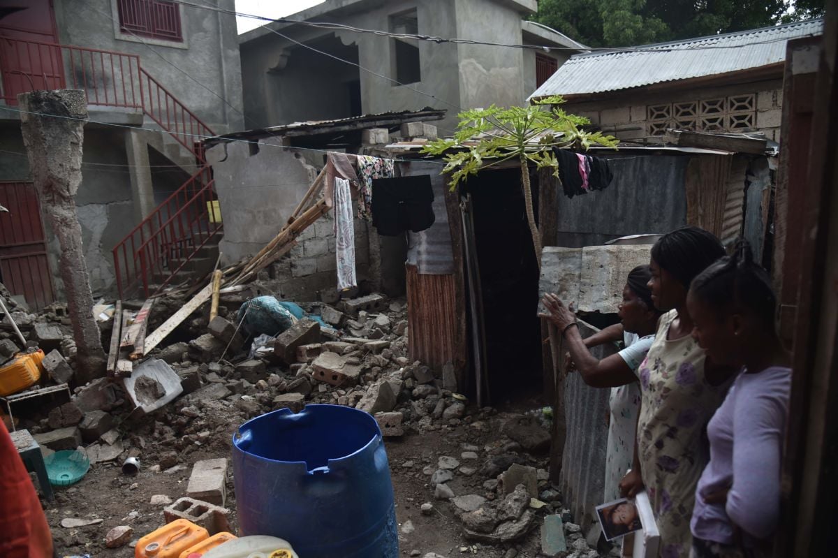 A family looks at the rubbles of their destroyed house in Gros Morne, Haiti, on October 8, 2018.