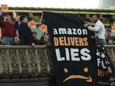 Protesters unfurl anti-Amazon banners from the balcony of a hearing room during a New York City Council Finance Committee hearing titled "Amazon HQ2 Stage 2: Does the Amazon Deal Deliver for New York City Residents?" at New York City Hall, January 30, 2019.