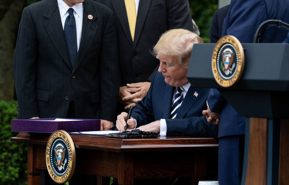 President Donald Trump signs S. 2372, the VA Mission Act of 2018, at a ceremony in the Rose Garden of the White House, June 6, 2018.