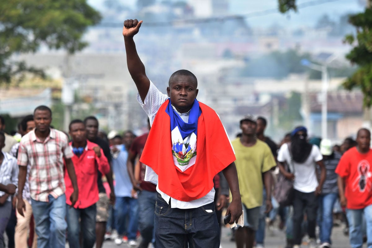 A man holds up his fist as demonstrators march through the streets of Port-au-Prince, on November 23, 2018, demanding the resignation of Haitian President Jovenel Moïse.