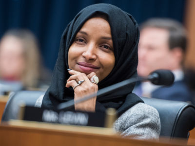 Rep. Ilhan Omar listens during Congressional meeting