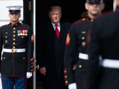 Flanked by officers, donald trump hides in a shadowy doorway