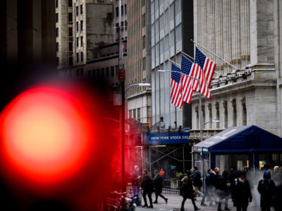 People pass the New York Stock Exchange in New York City