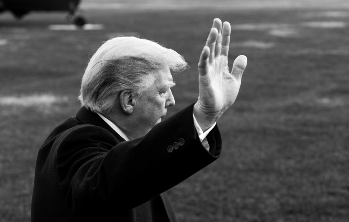 Donald Trump waves as he walks across White House lawn.