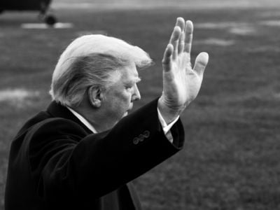 Donald Trump waves as he walks across White House lawn.