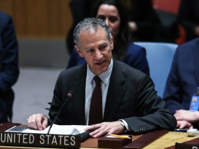 Jonathan Cohen sits at desk in the United Nations and speaks into a microphone