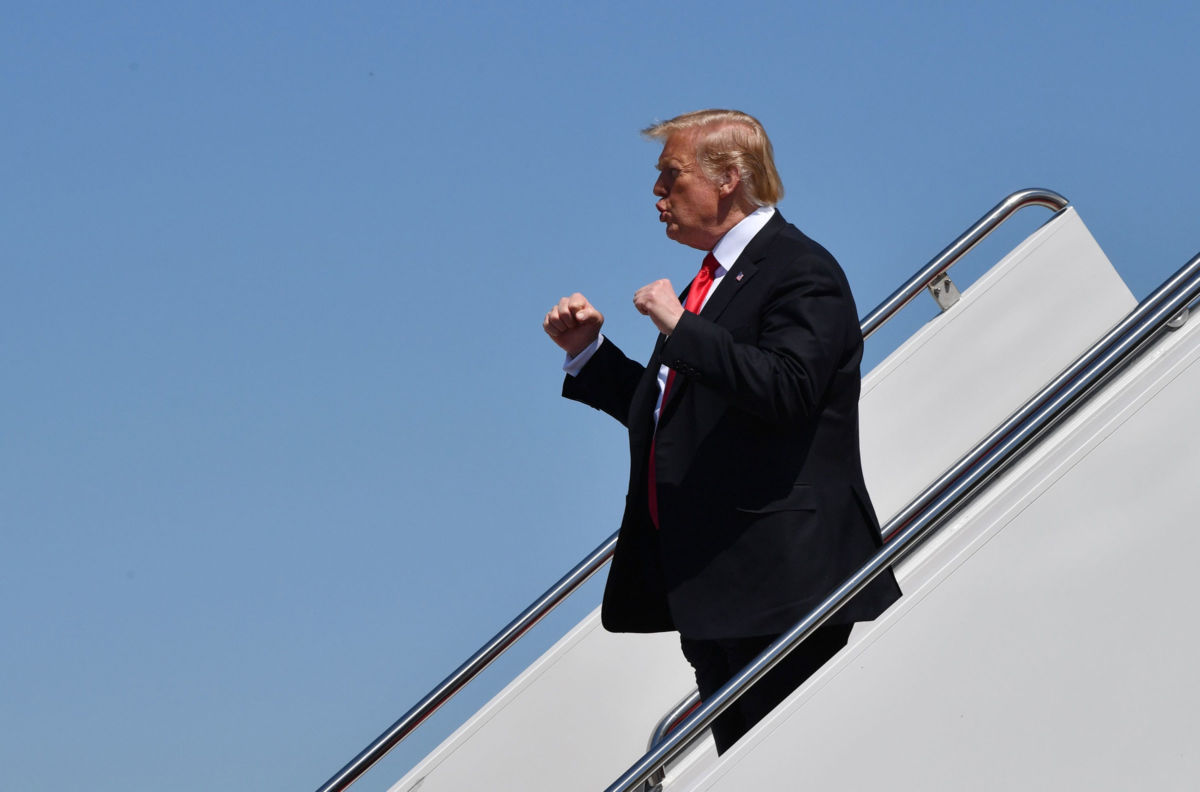 Donald Trump with his fists up departing plane in Florida