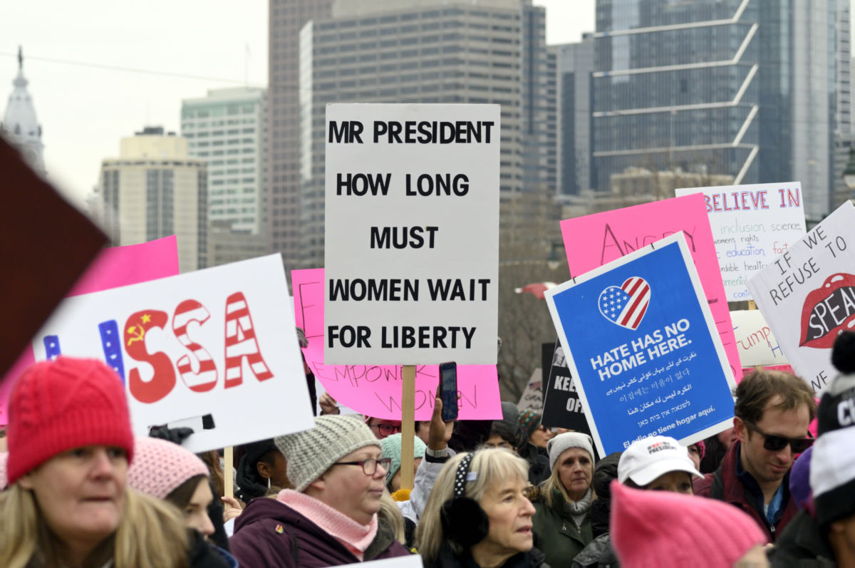 Signs are raised in the air as thousands gathered in Center City Philadelphia, PA to partake in protests during the third annual Women's March on January 19, 2019, and in similar events around the US.