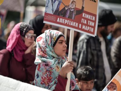 A young woman holds a placard as she takes part in a march in central Athens, Greece, on March 8, 2019, during a women's strike to mark the International Women's Day.