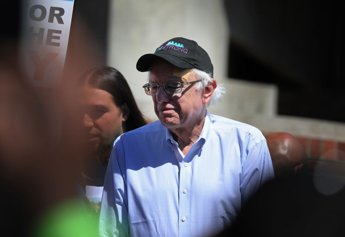 Bernie Sanders squints into the sun at rally while wearing a black hat