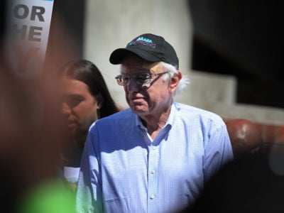 Bernie Sanders squints into the sun at rally while wearing a black hat