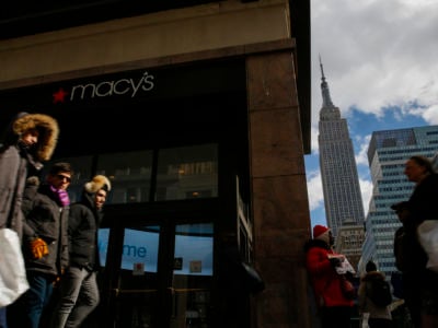 People walk in front of the Macy's headquarter as the Empire State Building is seen at the background on February 25, 2019, in New York City.