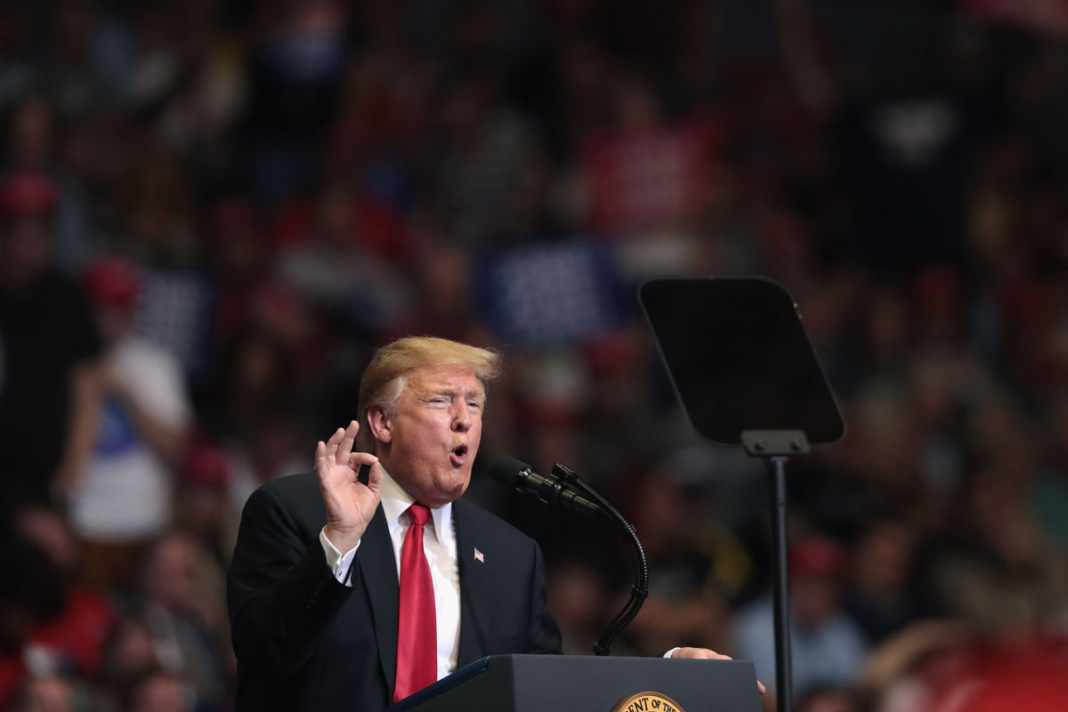 Donald Trump speaks into a microphone during a rally
