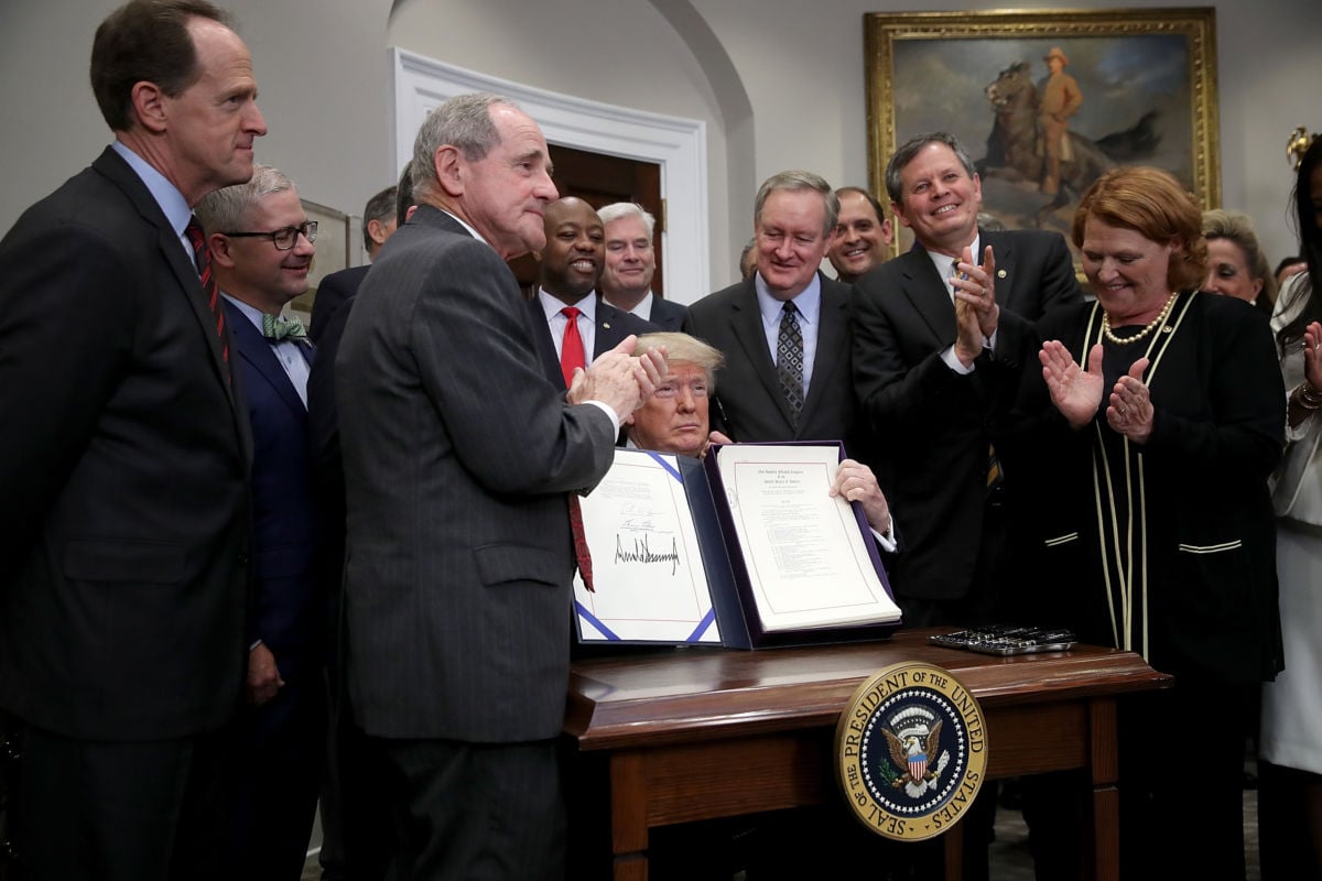 President Donald Trump displays the "Economic Growth, Regulatory Relief, and Consumer Protection Act" after signing the bill in the Roosevelt Room of the White House May 24, 2018, in Washington, DC. Senate Democrats played in key role in the passage of the bill.