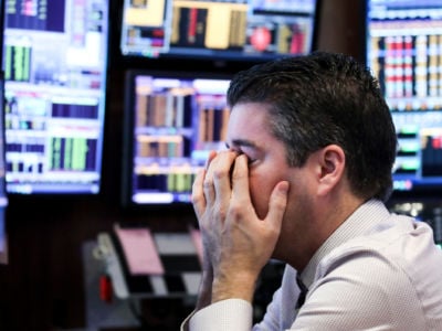 A trader covers his face at the New York Stock Exchange