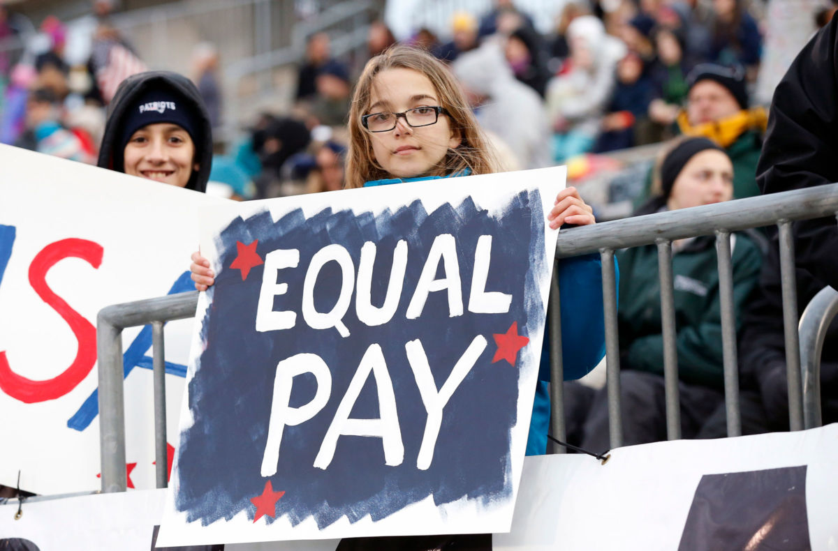 A young USA soccer fan with a message on equality in pay.