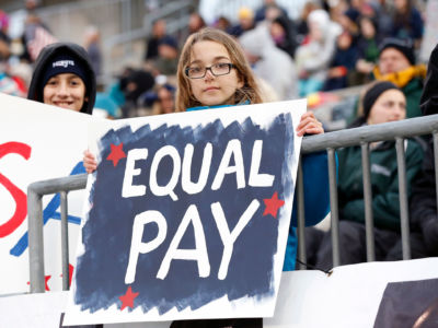 A young USA soccer fan with a message on equality in pay.
