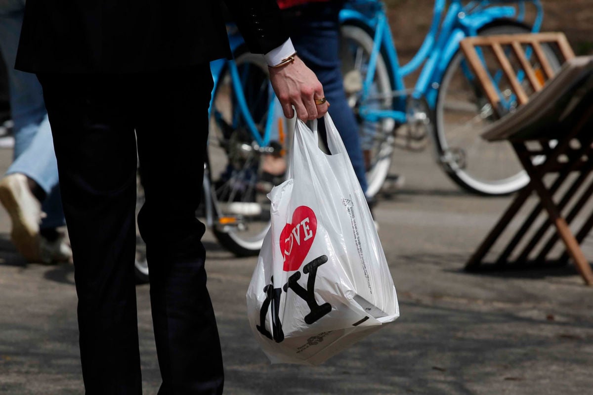 A man holds a plastic shopping bag as he visits Central Park on April 26, 2018, in New York City.