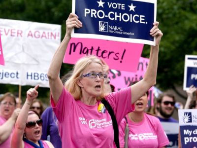 A woman holds a pro-choice sign during a large protest