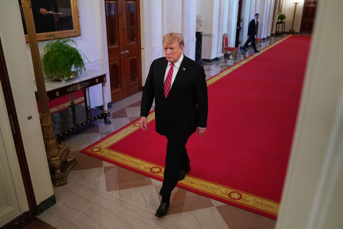 Donald Trump walks down a hallway