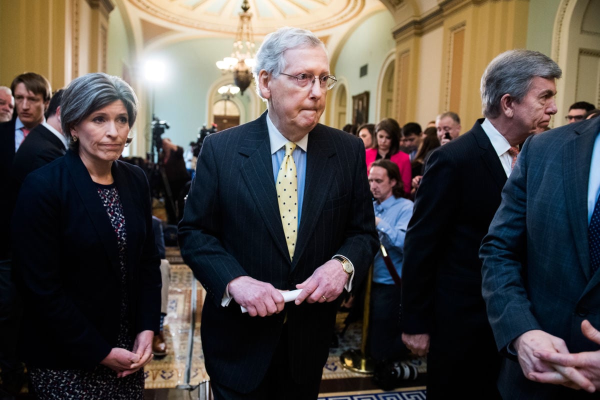 Mitch Mcconnell is flanked by Joni Ernst and Roy Blunt in a hallway