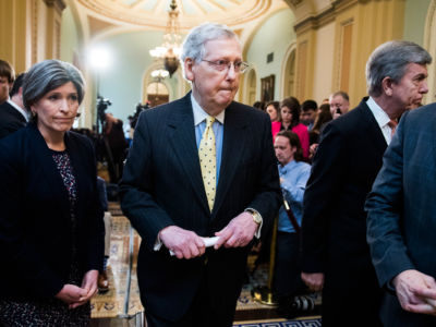 Mitch Mcconnell is flanked by Joni Ernst and Roy Blunt in a hallway