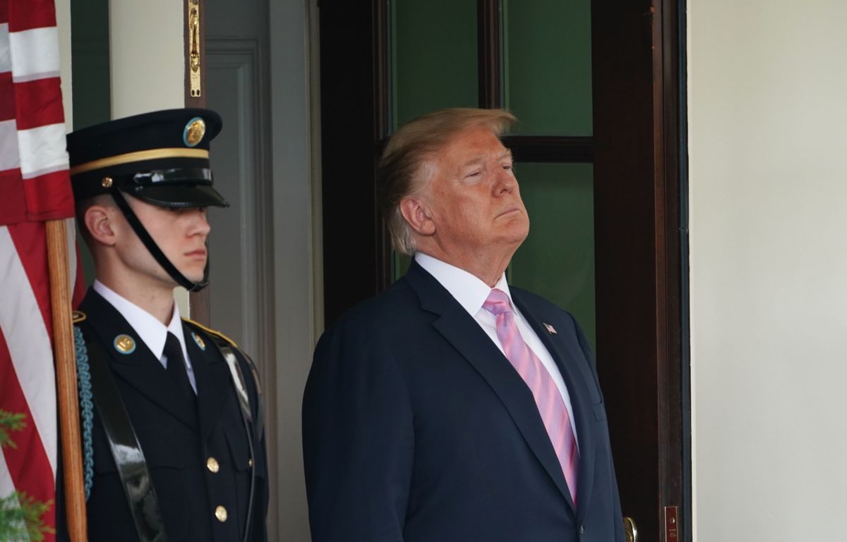 Donald Trump stands in a doorway at the White House