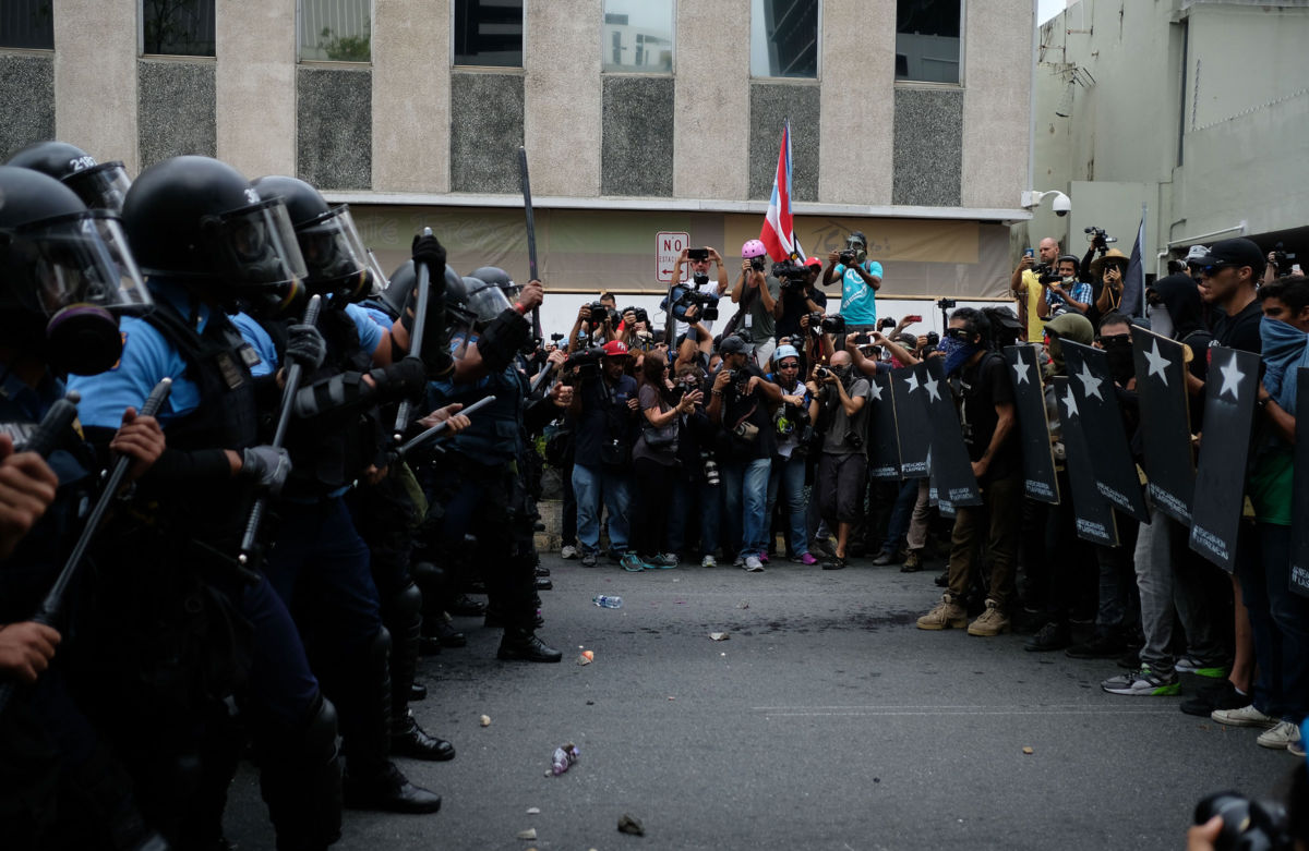 Police form a line in front of protesters during a May Day protest in San Juan, Puerto Rico