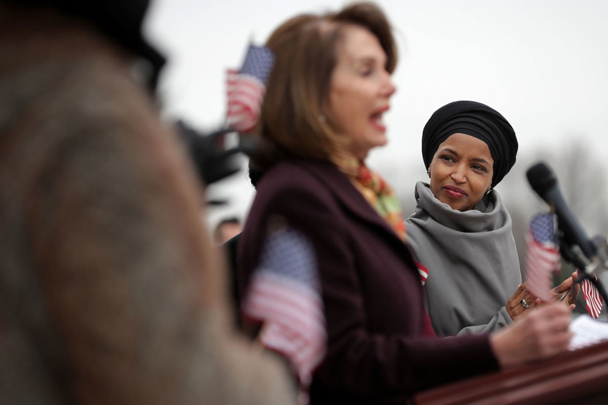 Rep. Ilhan Omar listens to Speaker Nancy Pelosi on the steps of the U.S. Capitol