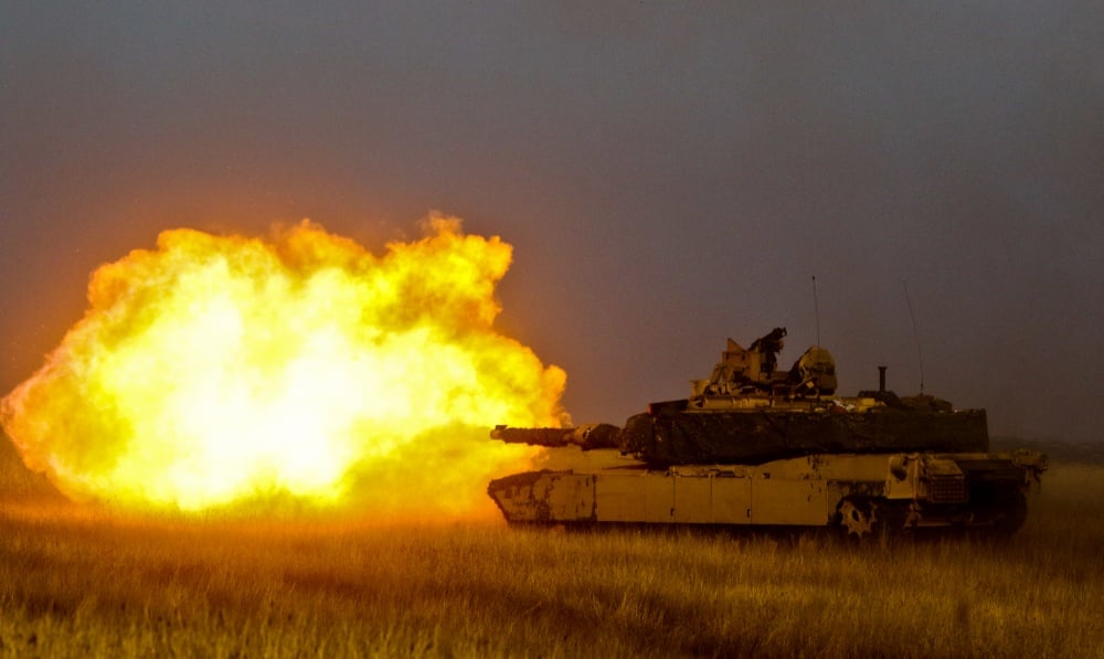 A tank shoots a missile in a fiery explosion