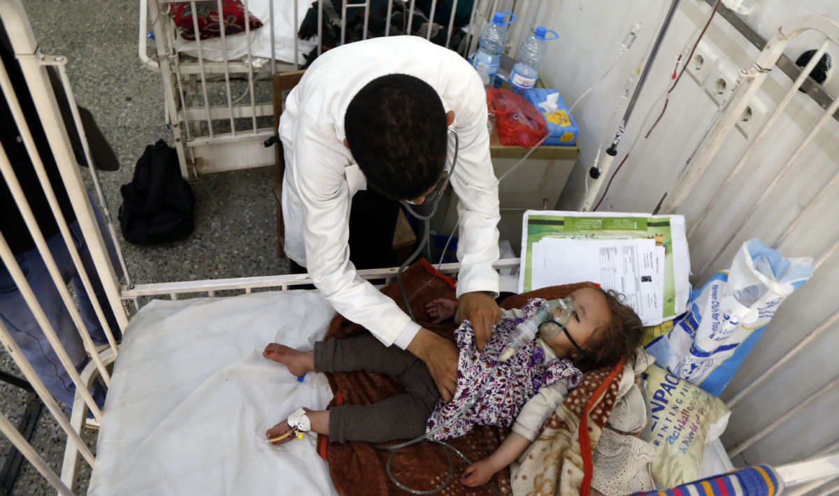 a little girl recieves care from a doctor while lying in a hospital bed