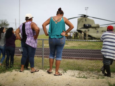 Local residents watch after a U.S. Army helicopter landed during food and water delivery efforts four weeks after Hurricane Maria struck on October 18, 2017, in Utuado, Puerto Rico.