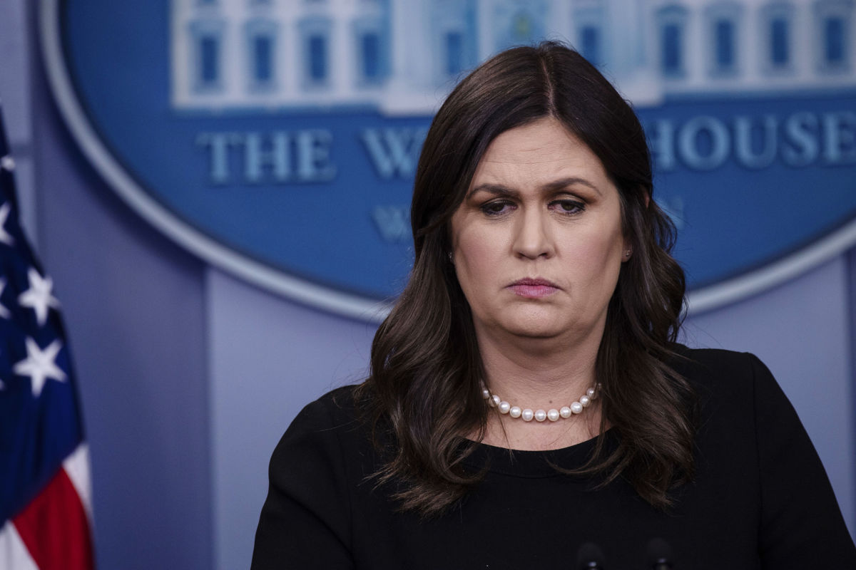 Sarah Huckabee Sanders looks onward while standing at a podium