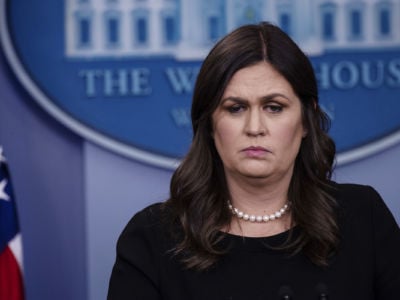 Sarah Huckabee Sanders looks onward while standing at a podium