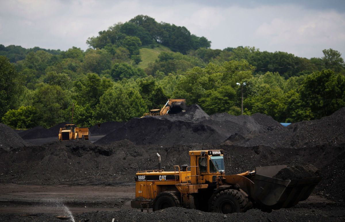 Caterpillar front-loading machinery operates on mounds of coal at Arch Coal Terminals, June 3, 2014, in Cattletsburg, Kentucky.