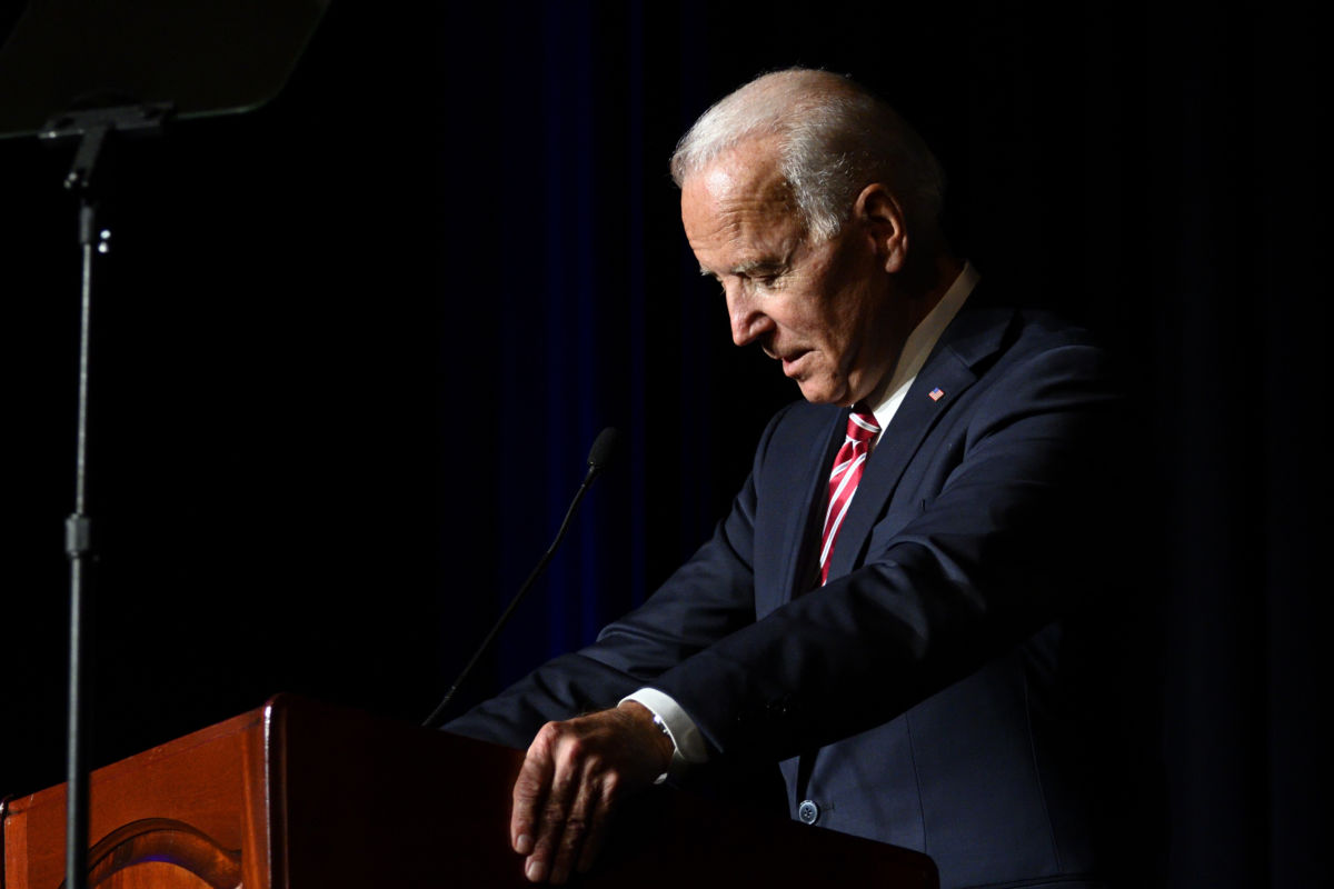 Joe Biden stands in profile at a podium