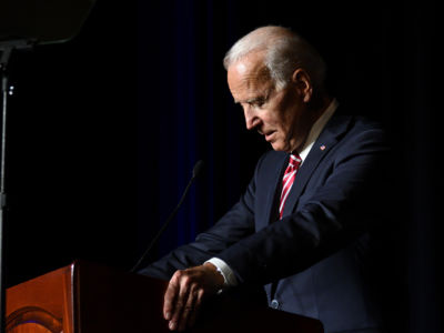 Joe Biden stands in profile at a podium