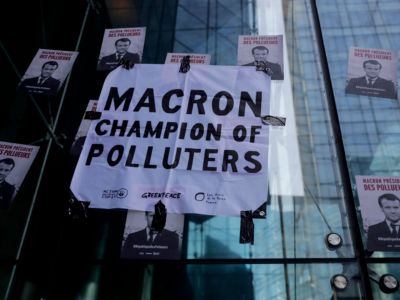 Posters displayed by Climate change activists near the entrance of the Societe Generale bank headquarters in La Defense, near Paris, depicting French President Emmanuel Macron with the words "Macron President of polluters" during an environmental protest called by the NGO Extinction Rebellion.