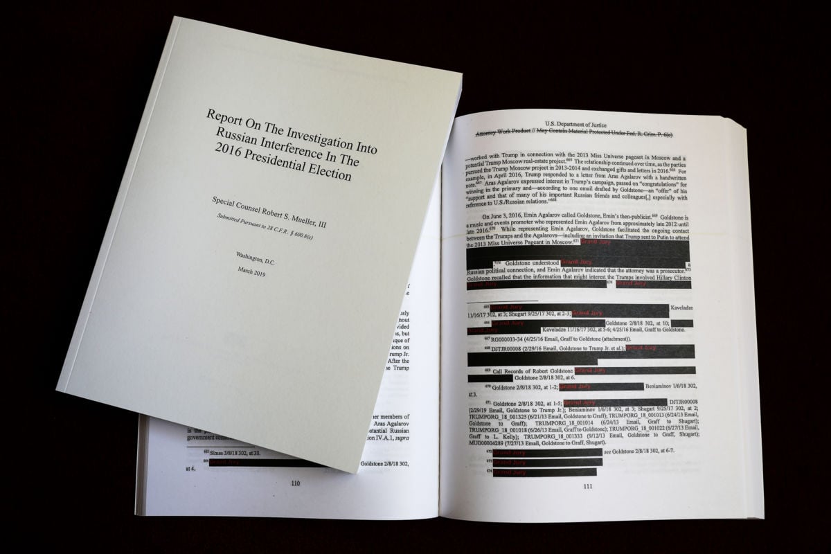 Pages of the redacted Mueller report sit open on a desk