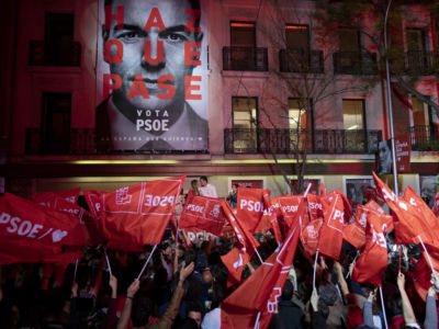 Spanish Prime Minister Pedro Sanchez kisses his wife Maria Begona Gomez as his supporters wave flags in the air outside of the PSOE (Spanish Socialist Workers’ Party) headquarters on April 28, 2019, in Madrid, Spain.