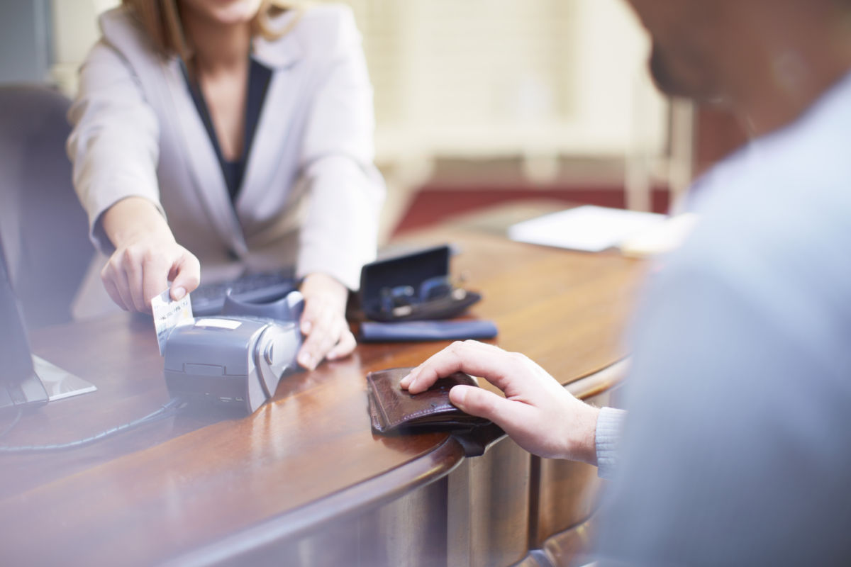 A person slides their bank card through a card reader