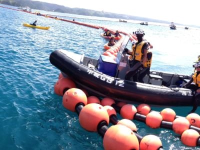 A man stands in an inflatable raft in the ocean