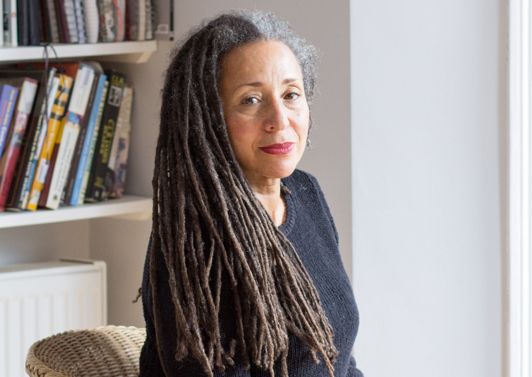 Jackie Walker, wearing a black shirt, sits in a chair