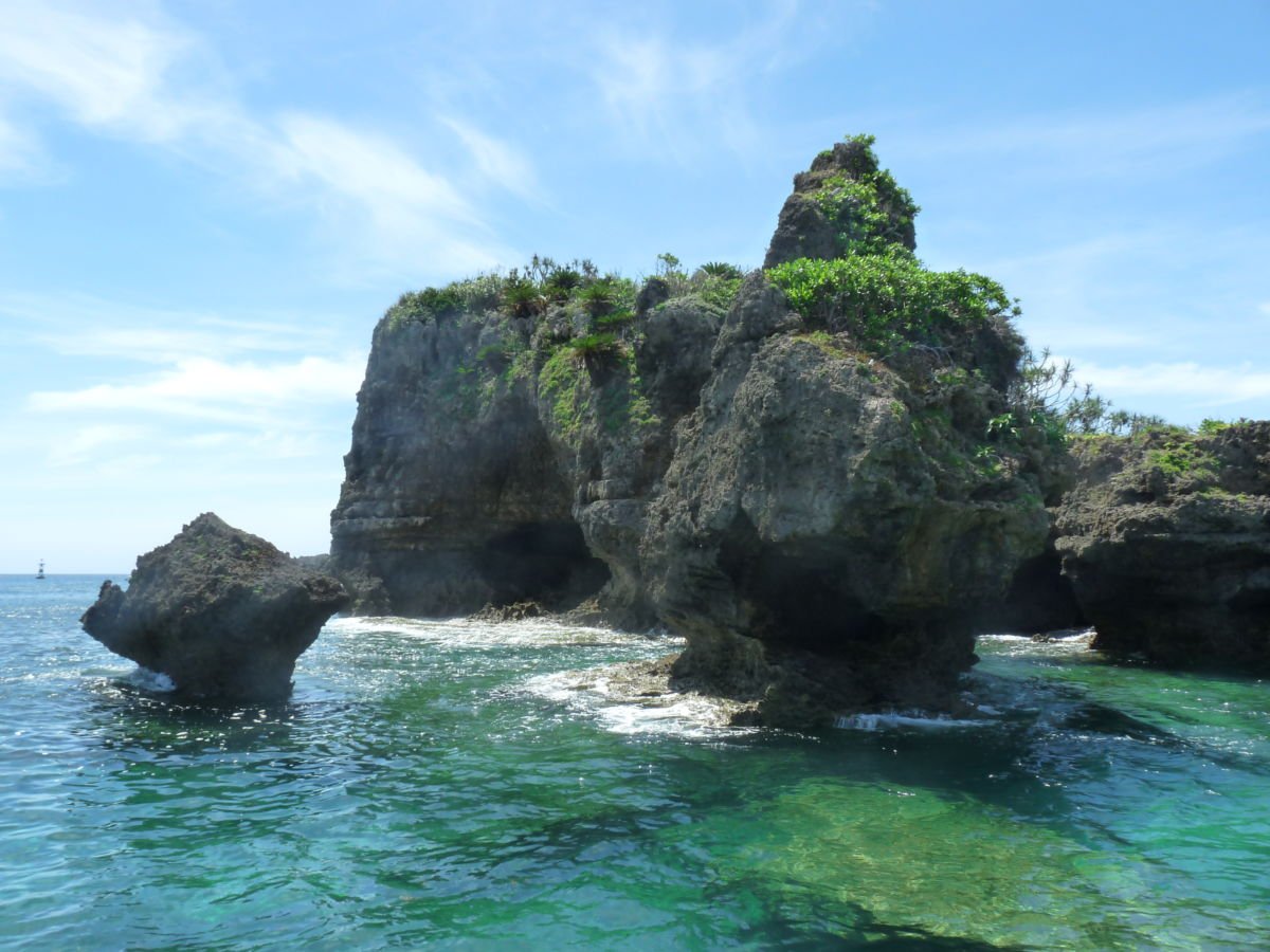 Plant-topped mountains rise from the ocean