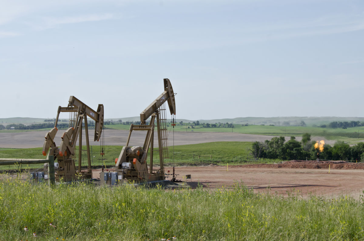 Two drills pump the ground for oil as moisture flares up in the separator.